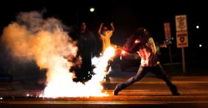 this tragic incident has sparked a necessary, national conversation about the need to ensure trust and build strong relationships between law enforcement officials and the communities they serve", said Holder. Pictured here: A rioter throws back a black tear gas canister at police. 