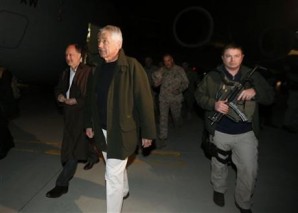 Secreatry of Defense Hagel in Afghanistan flanked by private security contractor carrying a Mp5 machine gun with dual magazine tapped togetehr for rapid reload. 