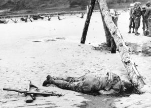 An American soldier lays dead on Normandy Beach. He was shot multiple times by a German machine gunner. 