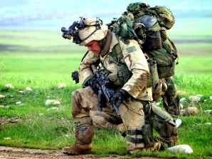 Soldier struggles under the weight of equipment and ammo he carries into battle. In much the same way the U.S. Military is struggling under the weight of sequester. 