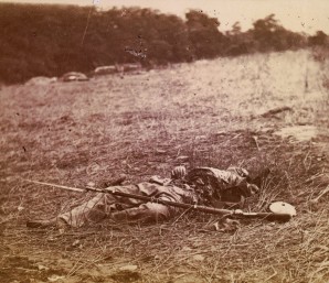 A dead Union soldier disemboweled by a cannon shot lays covered in a maggot swarm in July 1863. 