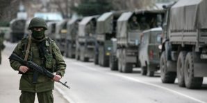 A wary Russian soldier. weapon at the ready guards a convoy  of 40 trucks carrying troops, military supplies and equipment into Crimea. 