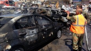 A picture taken with a smartphone on May 25, 2014, shows emergency teams extinguishing a fire at the site of a car bomb attack in a regime-held area in Syria’s central city of Homs. 