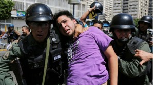 Venezuela police effect arrest on protester. 