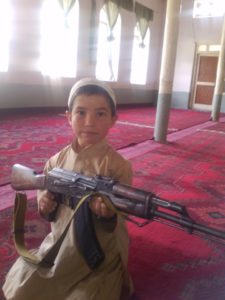 Child holding weapon inside a mosque in Pakistan. 