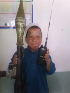 Child holding a RPG (Rocket Propelled Grenade) and walkie talkie used by militants in Pakistan. 