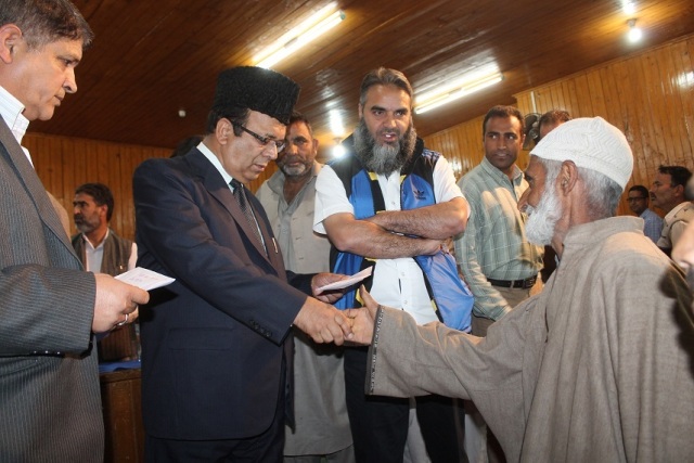 Minister for Finance and  Ladakh Affairs  Ab Rahim Rather  distributing relief cheques under IAY out of CDF