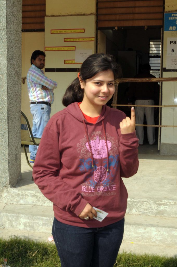 A young voter showing mark of indelible ink after casting her vote, at a polling booth, during the Delhi Assembly Election, in Delhi on February 07, 2015.