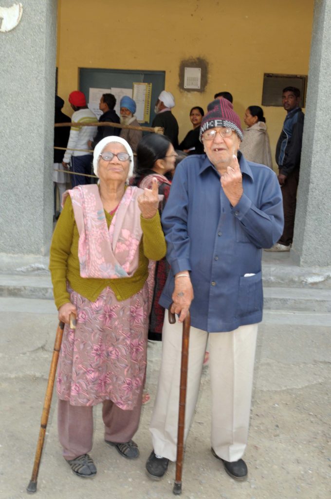 An elderly couple voters showing mark of indelible ink after casting their votes, at a polling booth, during the Delhi Assembly Election, in Delhi on February 07, 2015.