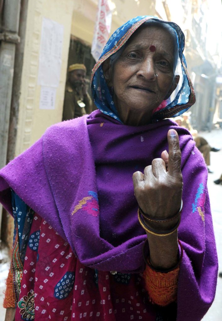 An Elderly woman voter showing mark of indelible ink after casting her vote, at a polling booth, during the Delhi Assembly Election, in Delhi on February 07, 2015.