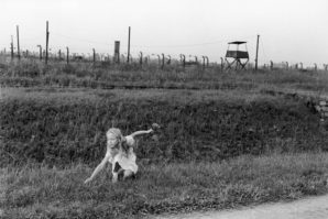 A little girl picks wild flowers  in the Bitkenau concentration camp in 1990. 